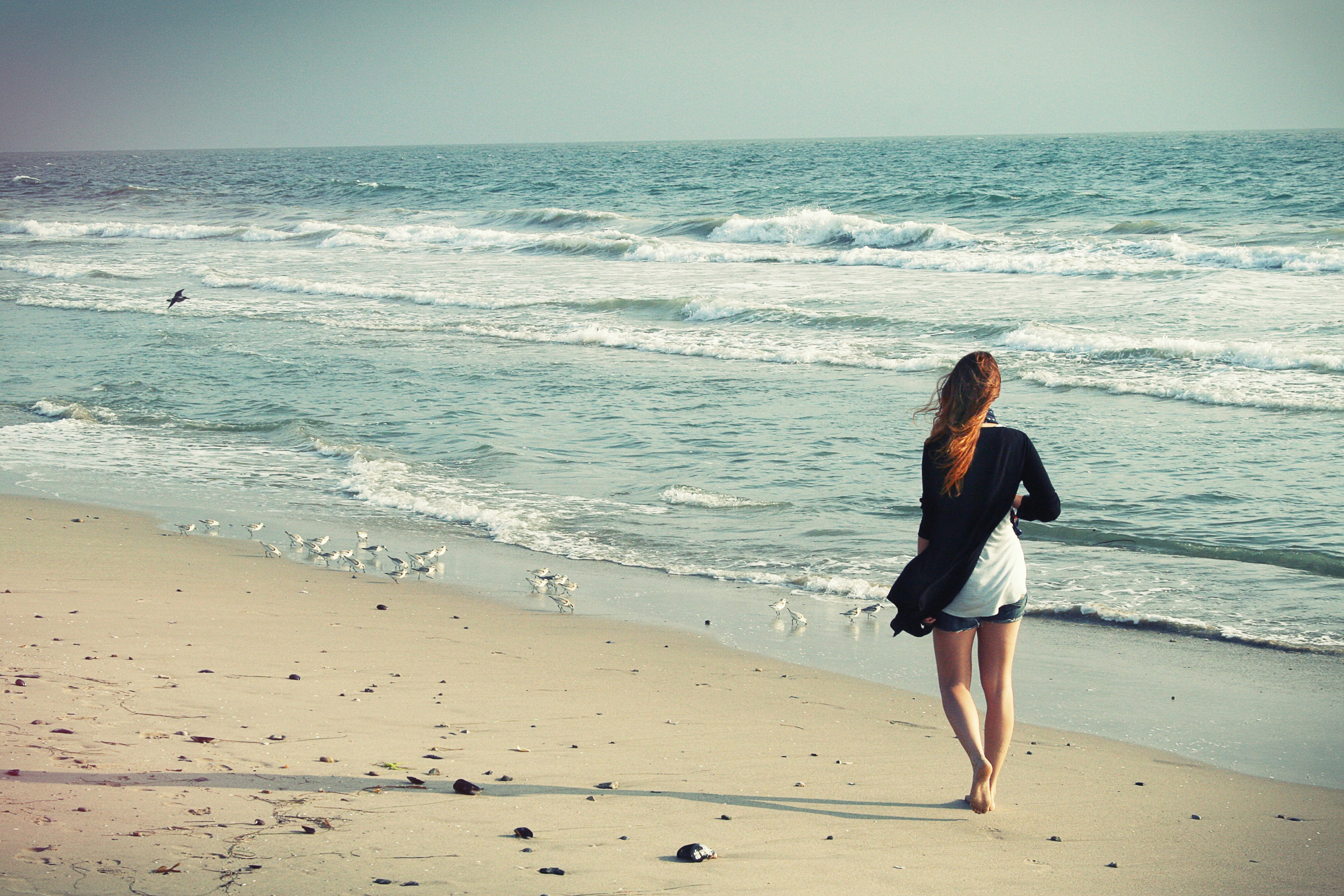 Woman walking in solitude on beach shore, signifying the healing process of therapy from North Shore Professional Therapy, MA. Sarah Haugh, LMHC, Therapist