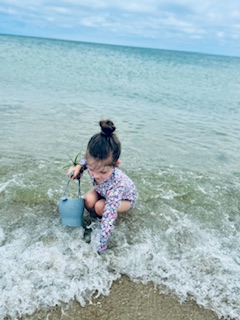 little girl, collecting sea glass in the ocean shore signifying the North Shore Professional Therapy Healing process. Sarah Haugh Therapist 01731 33326 01950