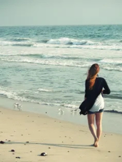 Woman walking in solitude on beach shore, signifying the healing process of therapy from North Shore Professional Therapy, MA. Sarah Haugh, LMHC, Therapist
