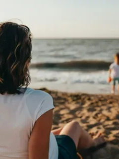 woman on shoreline watching child symbolizing the growth from child to adult and the tranquility neccessary to whether all changes in life. Sarah Haugh, LMHC