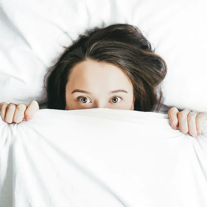 anxious woman hiding under covers due to her anxiety before anxiety therapy in mass