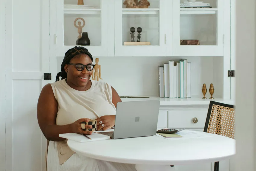 woman smiling at laptop, during a therapy session for trauma therapy or anxiety therapy at north shore professional therapy.