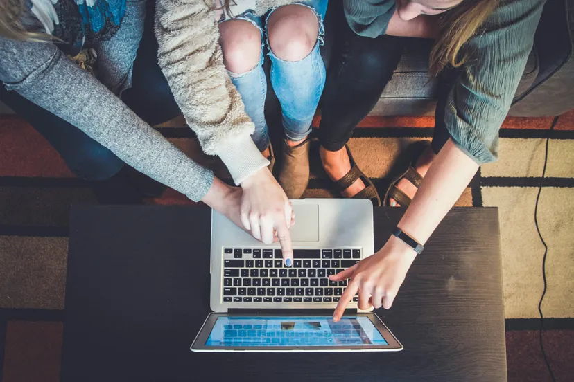 three teenage girls on laptop pointing to images representing typical teenage life and social media challenges leading to anxiety and depression.