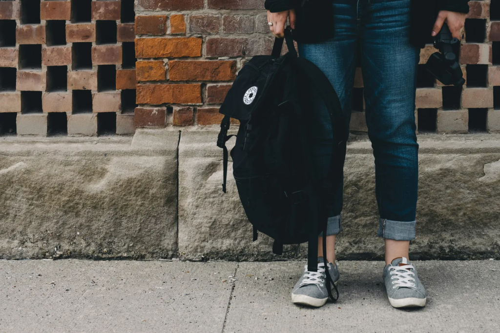 Teen girls feet and legs holding backpack representing school avoidance in teen girls due ot social anxiety or school anxiety