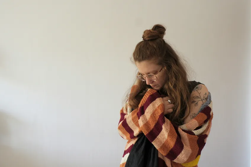 woman hugging self in need of counseling or therapy for anxiety or trauma from north shore professional therapy. learning self-compassion and healing.