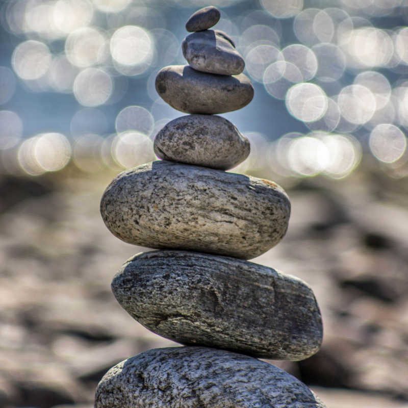 Rock tower on beach symbolizng peace and tranquility achieved from particpating in anxiety therapy at north shore professional therapy with Sarah Haugh, LMHC